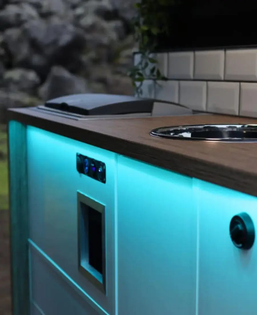 The kitchen of a Highlander III, lit in turquoise in the evening