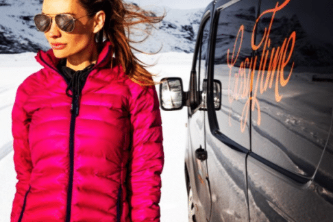 woman standing next to camper in Iceland