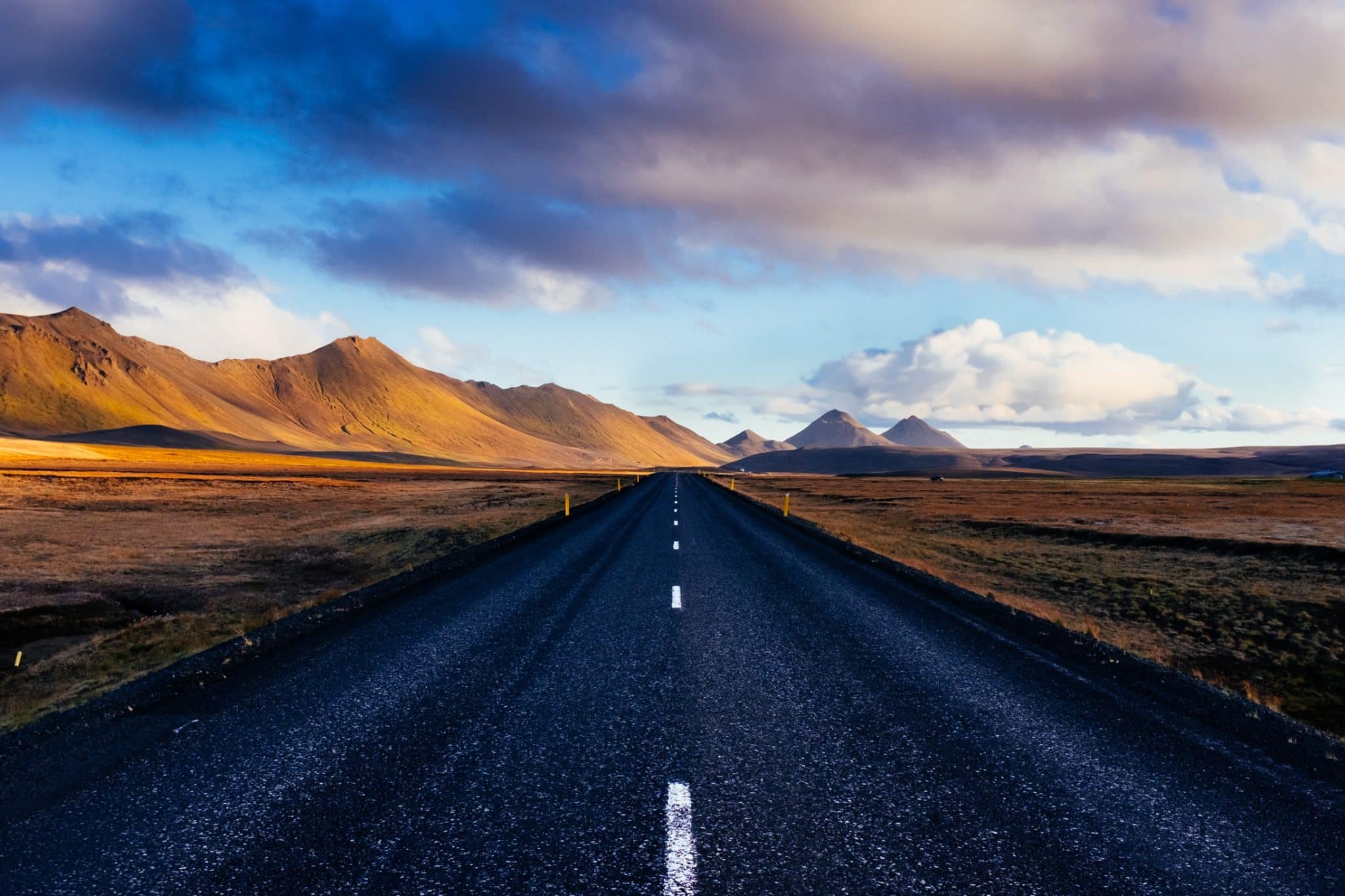 An open road with mountains in the background