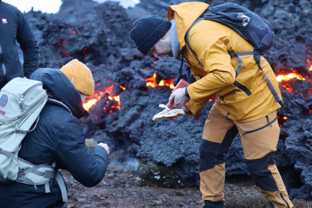 People eating hotdogs near a volcanic site in Iceland