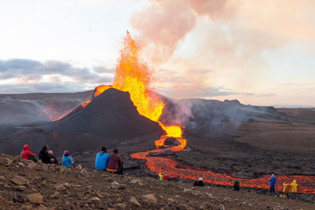 People watch a volcano erupting in Iceland