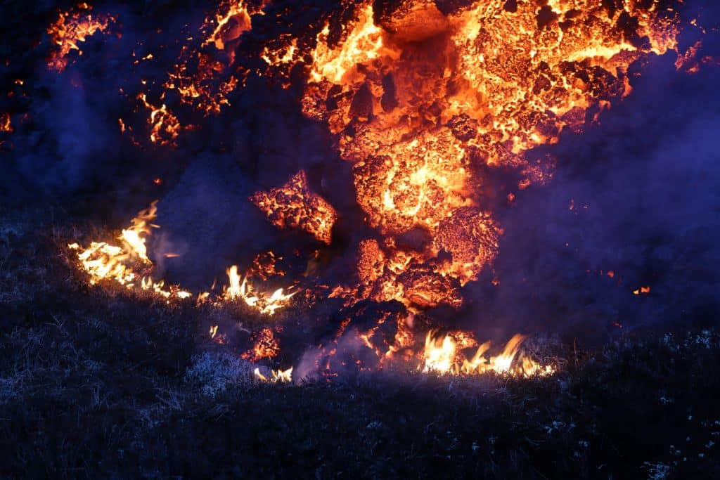 Lava from a volcano flowing into grass in Iceland