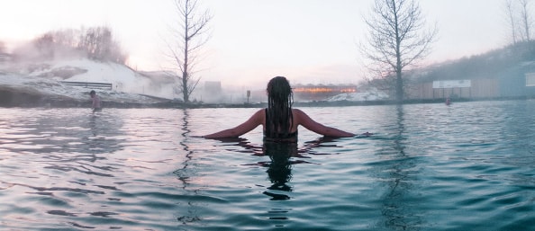 A woman in a blue thermal pool in Iceland